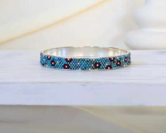 Beaded bracelet with blue and red pattern on a white surface